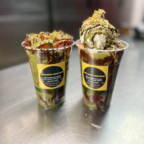 Two Golden Chicken dessert cups with strawberries, pistachio, chocolate, and ice cream.
